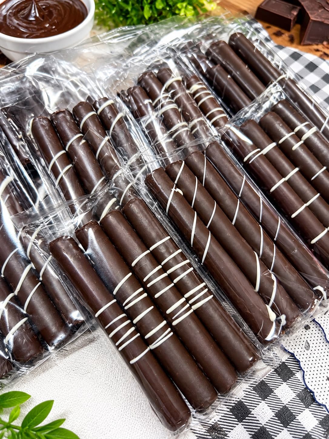 Palitos bañados en chocolate con líneas de chocolate blanco, envasados uno a uno