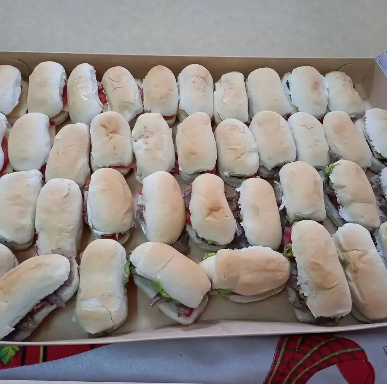 Bandeja grande con decenas de mini sándwiches en pan de completo