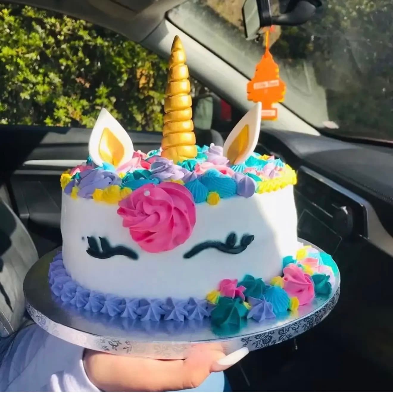 Torta infantil decorada de unicornio, con cuerno dorado y flores de colores